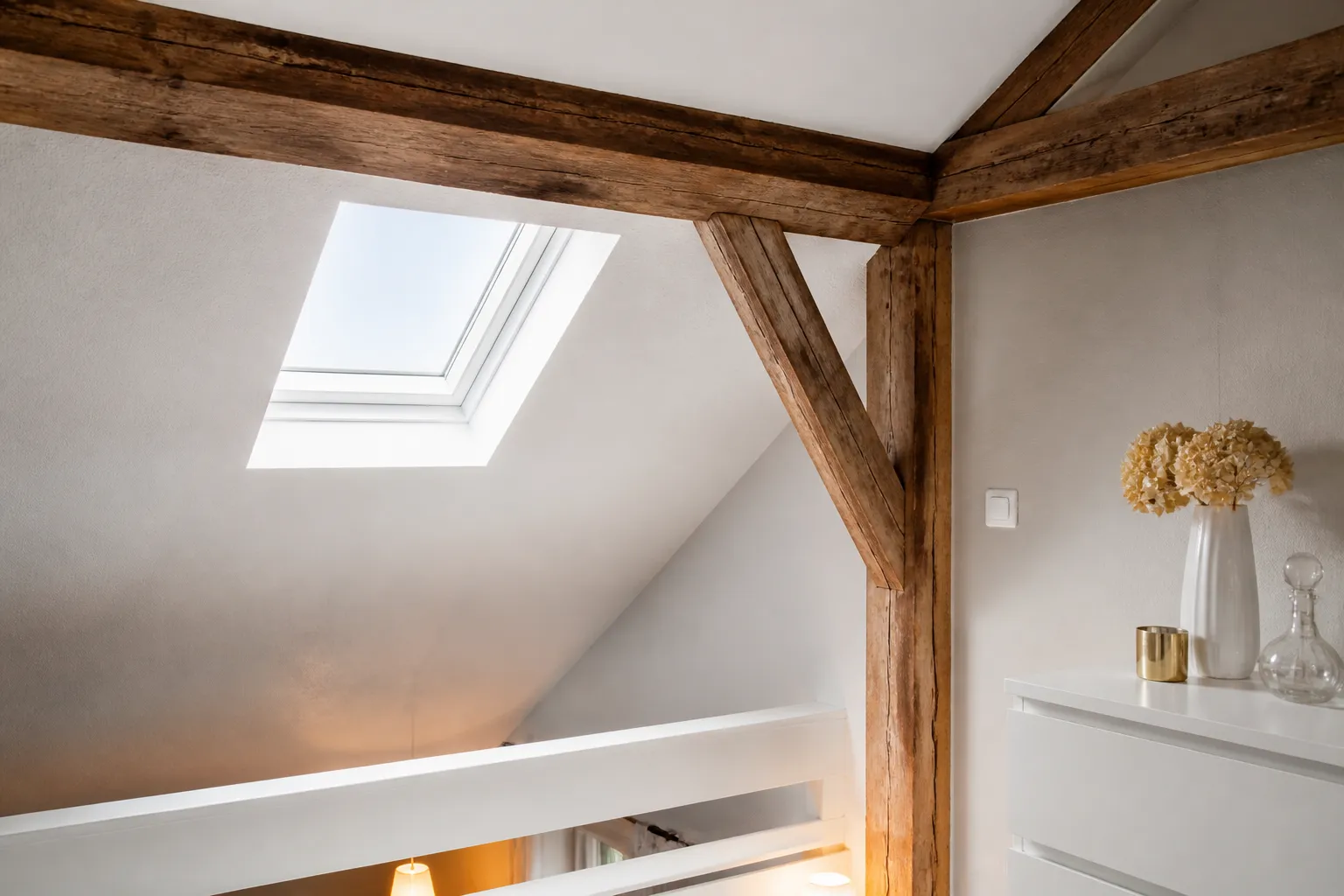 Petite fenetre de toit et poutres en bois dans un logement sous les toits