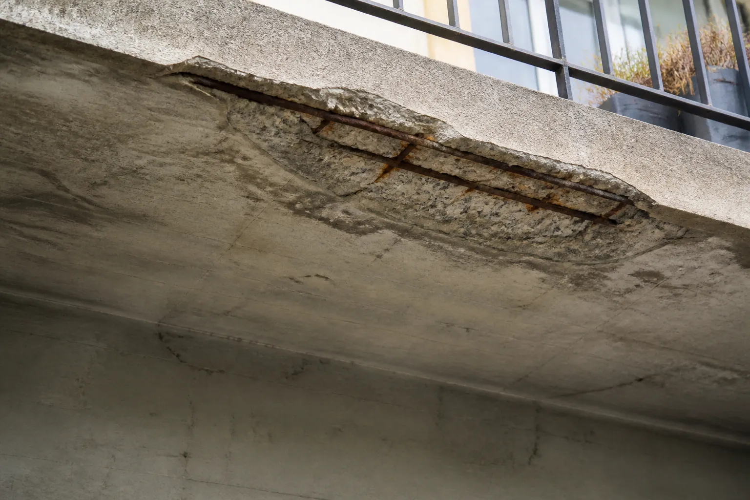 Sous face de balcon en beton avec eclat revelant une armature rouillee