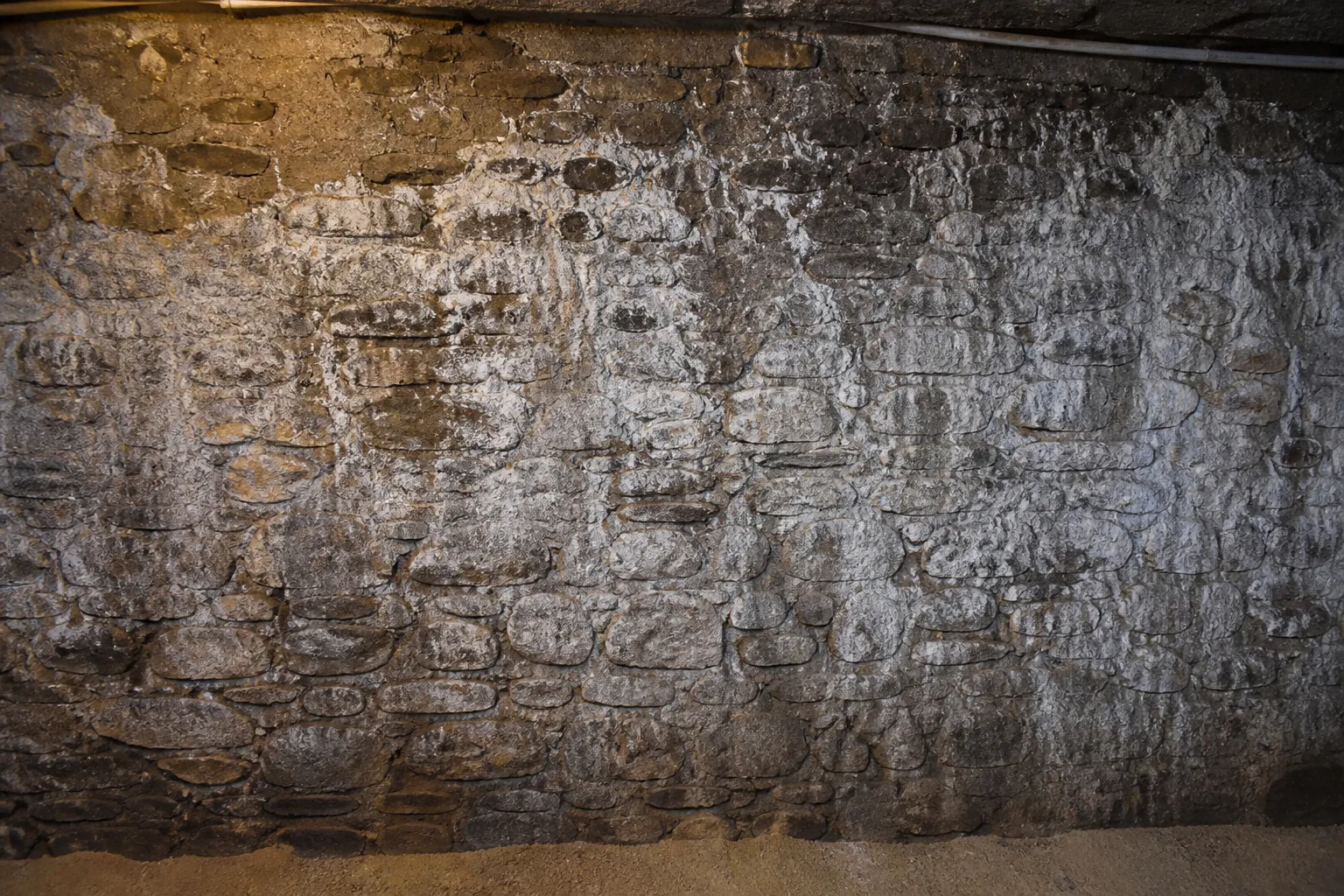 Mur de cave en moellons avec efflorescences blanches et traces d eau