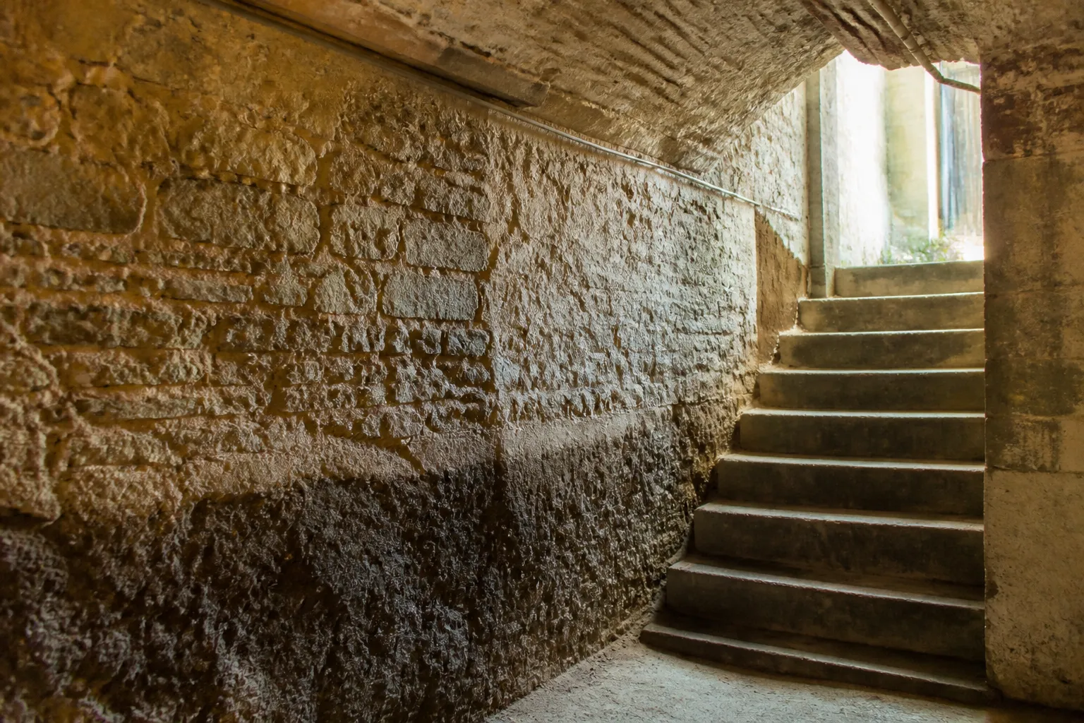 Escalier de cave avec trace de niveau d eau sur un mur en pierre