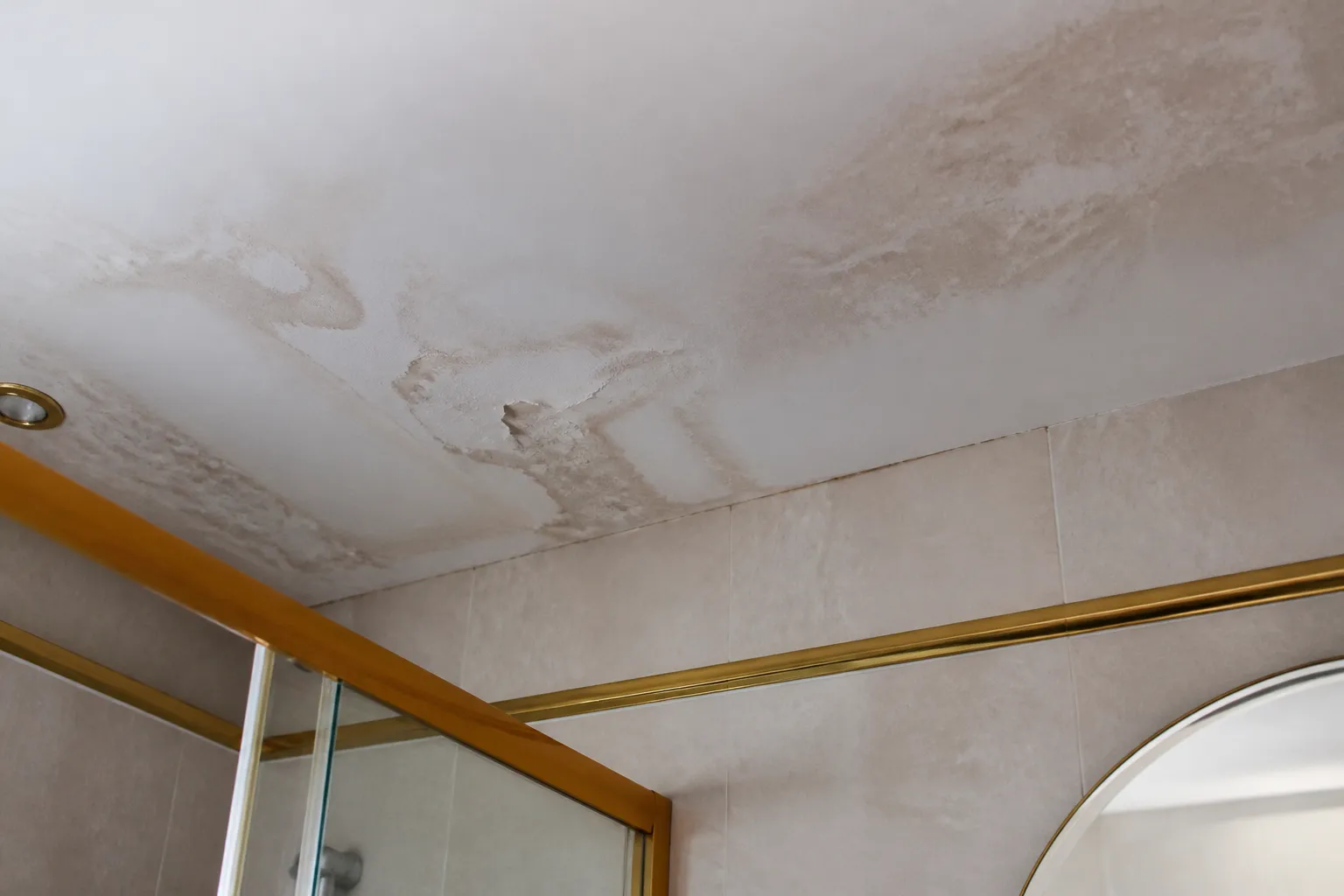 Plafond de salle de bains tache par une fuite venant de l etage superieur dans un immeuble ancien