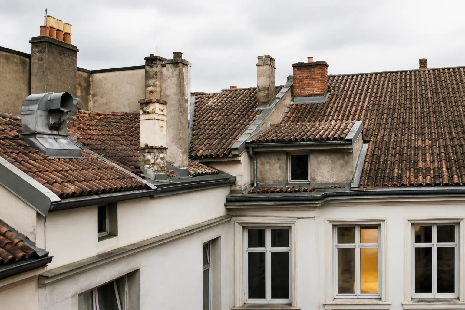 Toiture en tuiles d un immeuble ancien de Lyon vue depuis une cour interieure