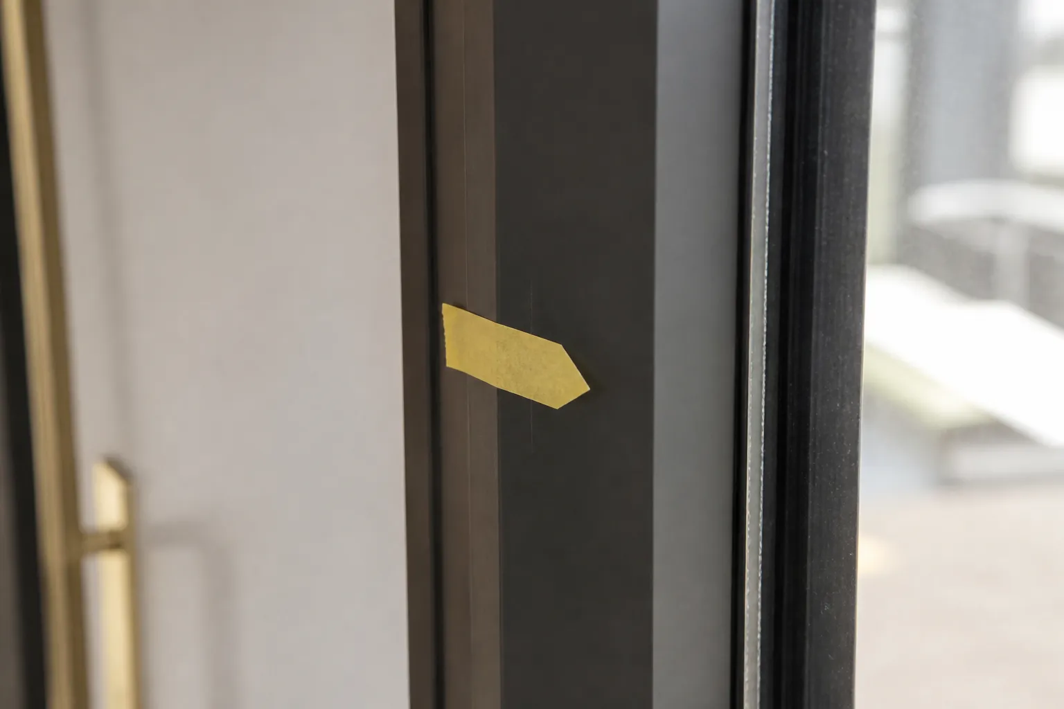 Ruban adhesif de couleur signalant une rayure sur une menuiserie neuve