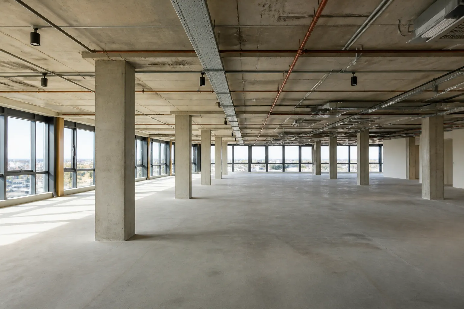 Plateau de bureaux vide avec poteaux en beton avant cloisonnement