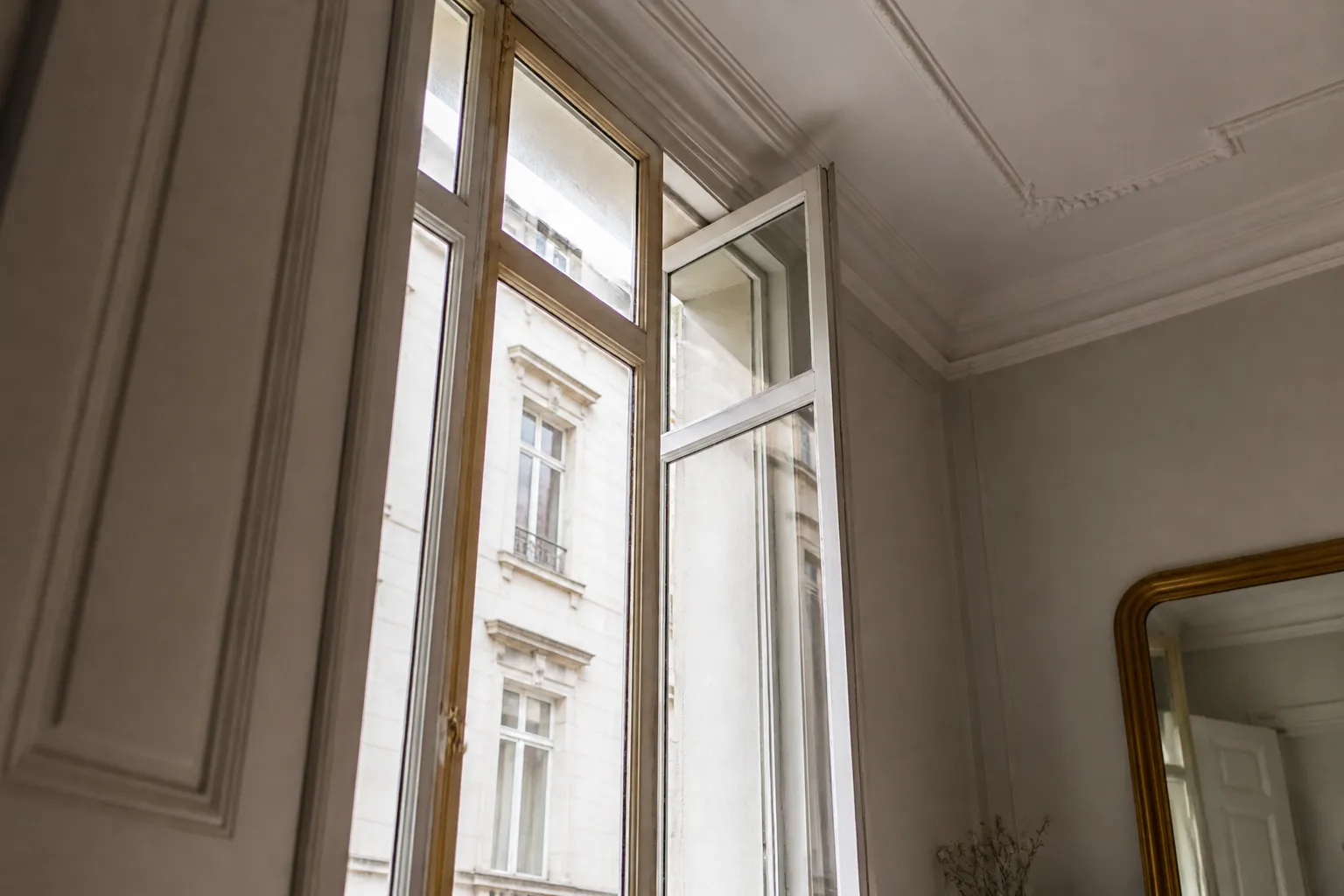 Haute fenetre en bois entrouverte dans un appartement ancien lyonnais