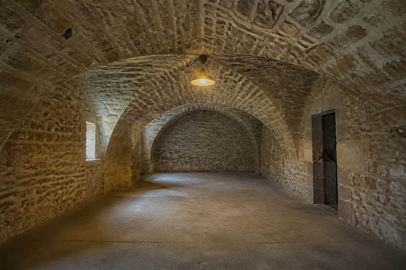 Cave voutee en pierre d un immeuble ancien eclairee par une lampe